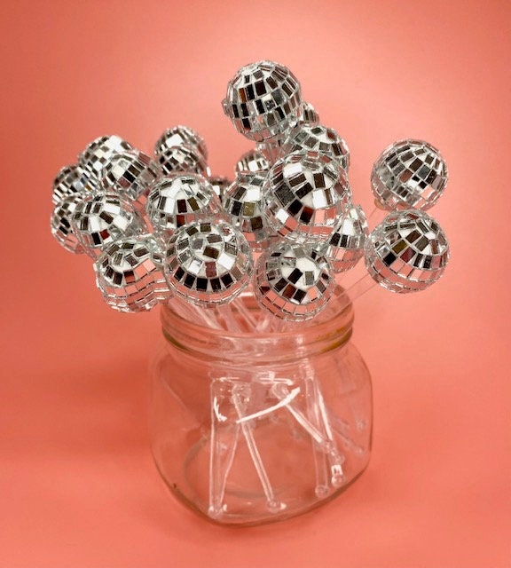 Party table setup with shimmering retro disco ball stir sticks